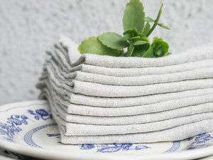 Folded natural linen napkins on plates