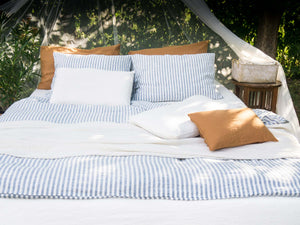 Outdoor bed with blue striped linen bedding 