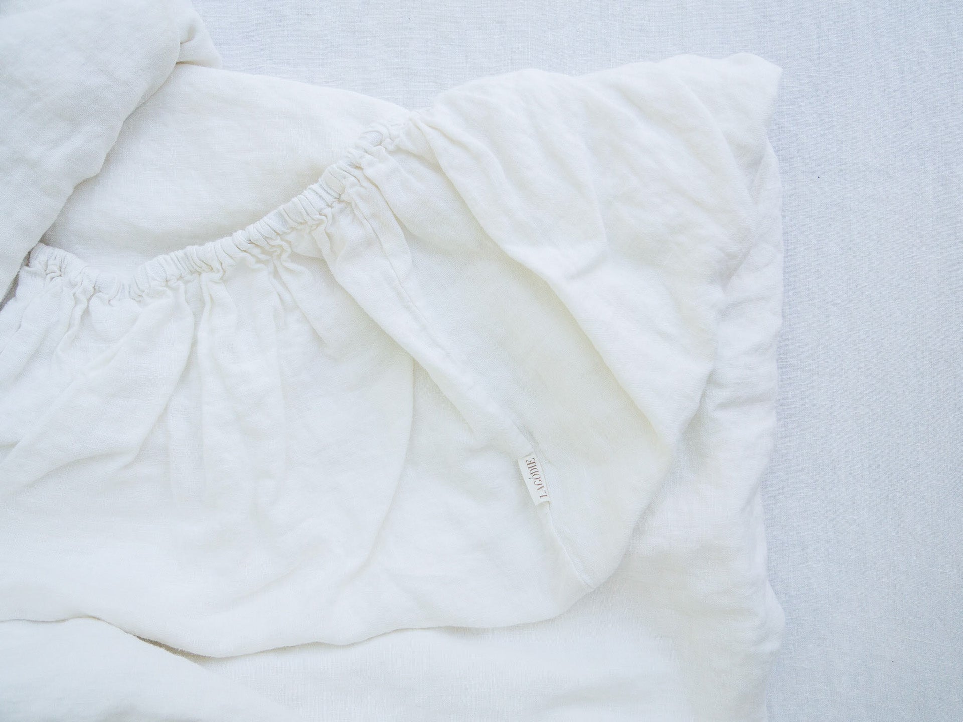 Unfolded White Linen Fitted Sheet from Above